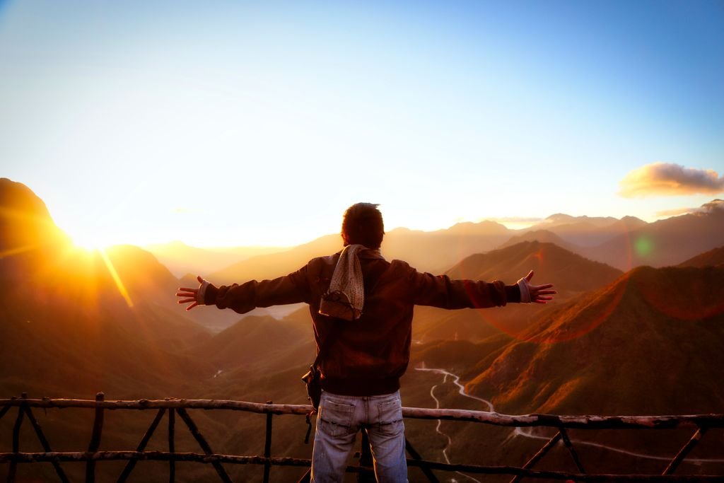 Silhouette of a person embracing the scenic sunset over the mountains in Tam Đường, Vietnam.